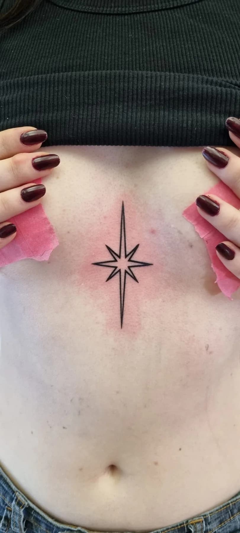 Eight-pointed star beneath the chest. Tattoo at Ink21 in Vienna.