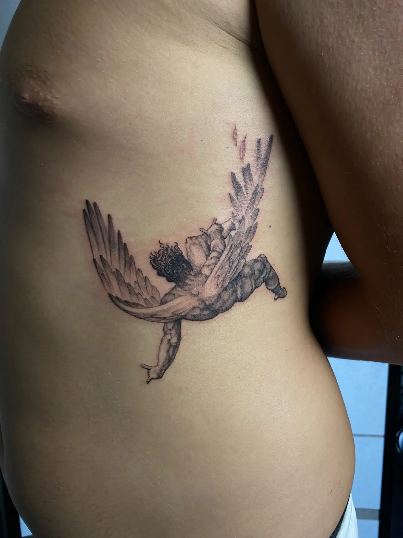 Falling angel on the side of the torso. Tattoo at Ink21 in Vienna.