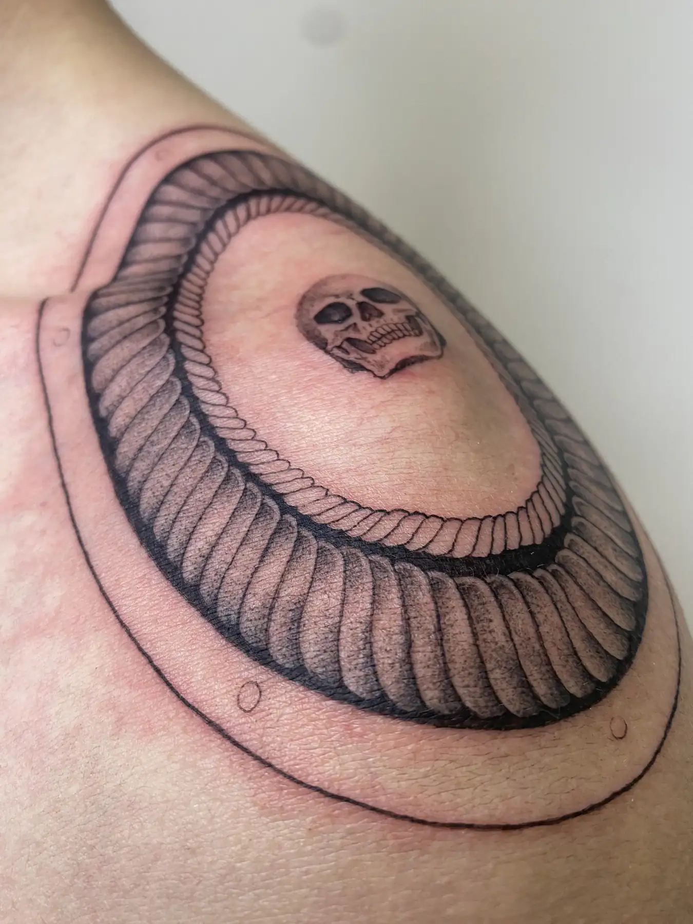 Ribbed loop around the elbow. Tattoo at Ink21 in Vienna.
