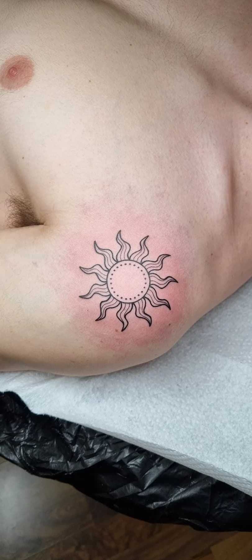 Small sun with wavy rays. Tattoo at Ink21 in Vienna.