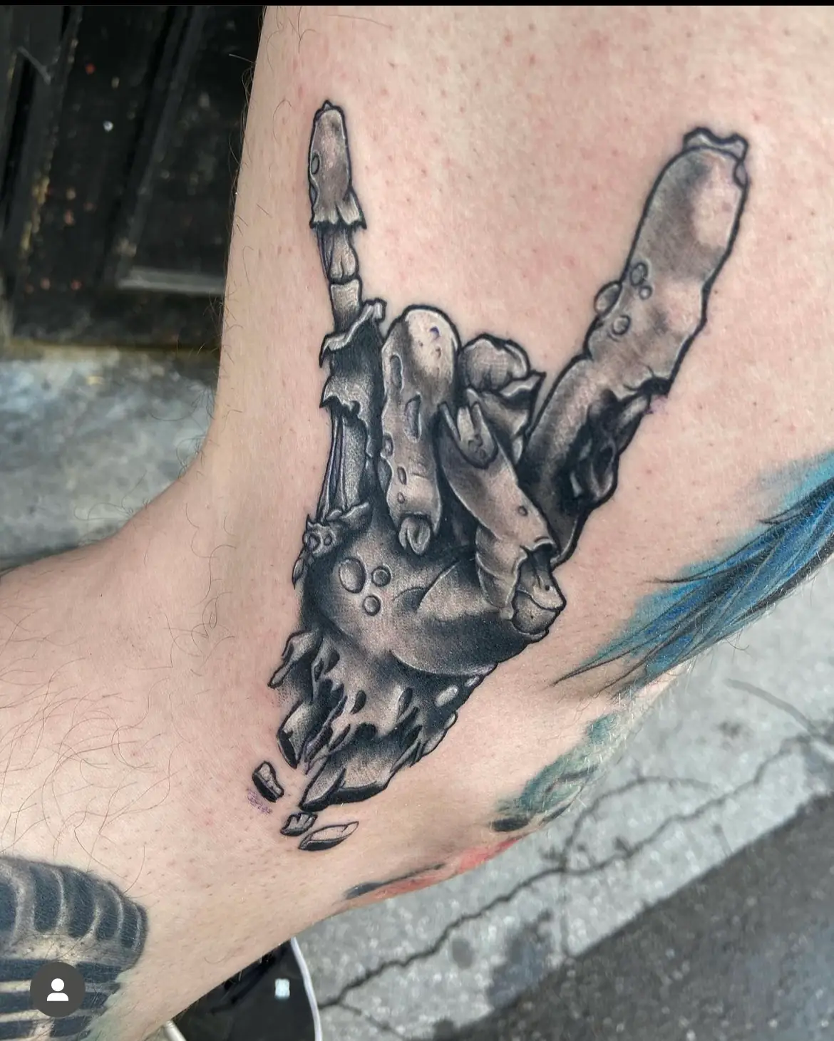 Bony hand making a rock sign. Tattoo at Ink21 in Vienna.
