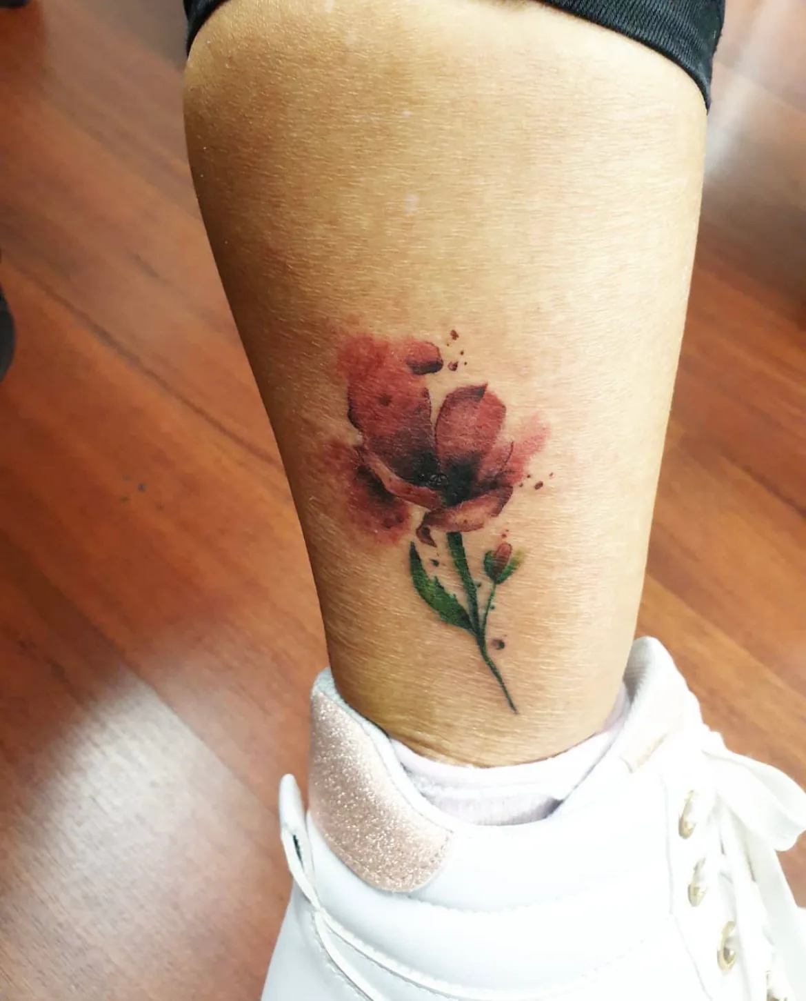 Red watercolour rose on the lower leg. Tattoo at Ink21 in Vienna.