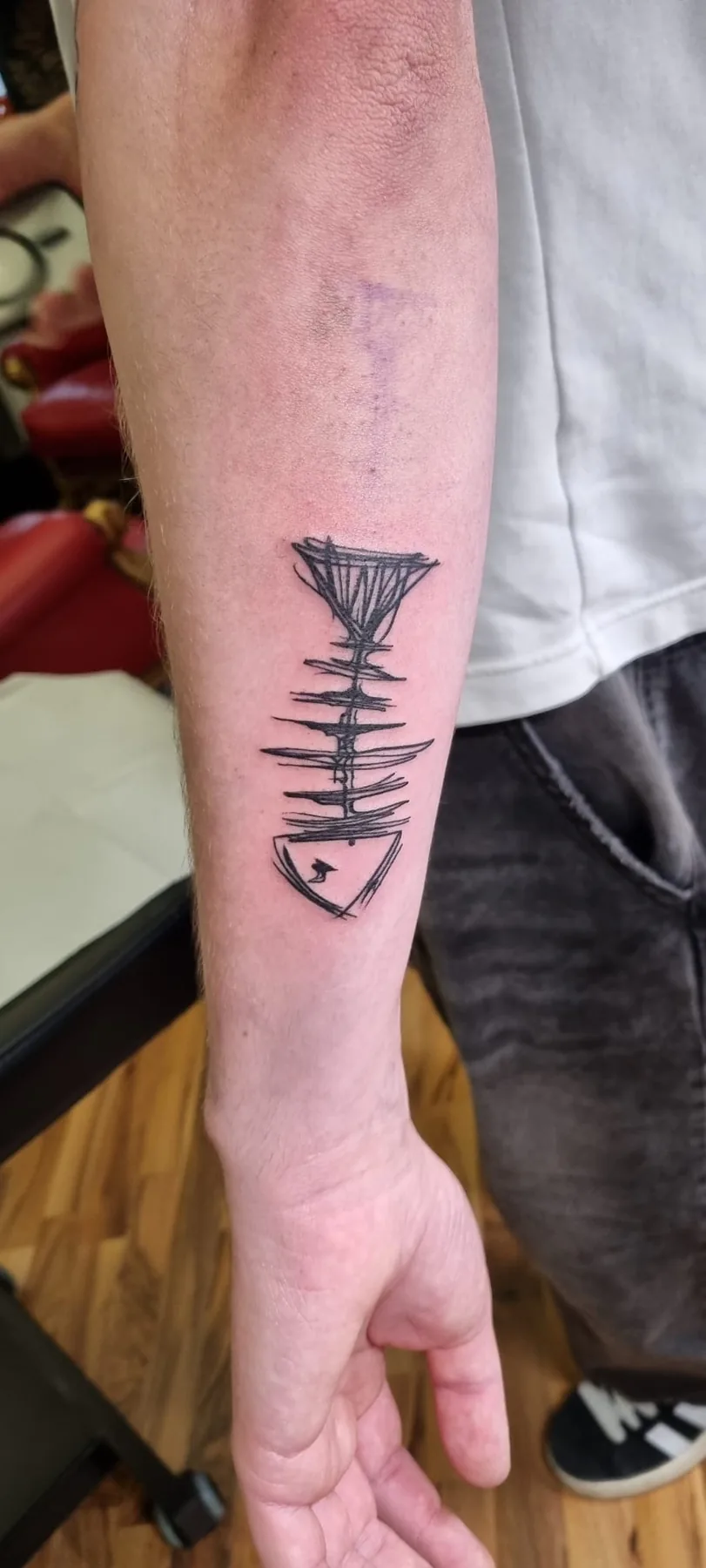 Black fish skeleton on the forearm. Tattoo at Ink21 in Vienna.