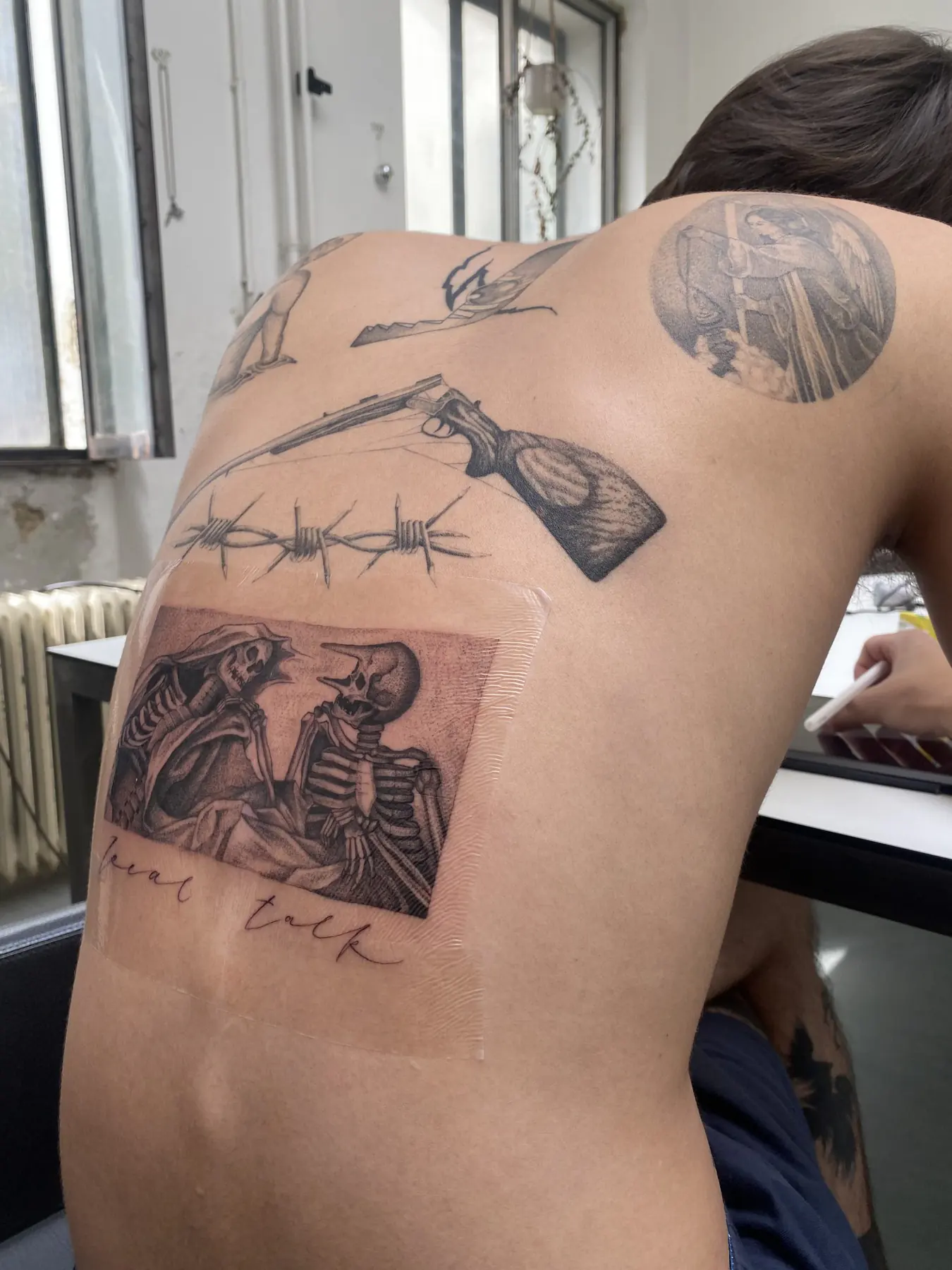 Skeleton scene among back tattoos. Tattoo at Ink21 in Vienna.