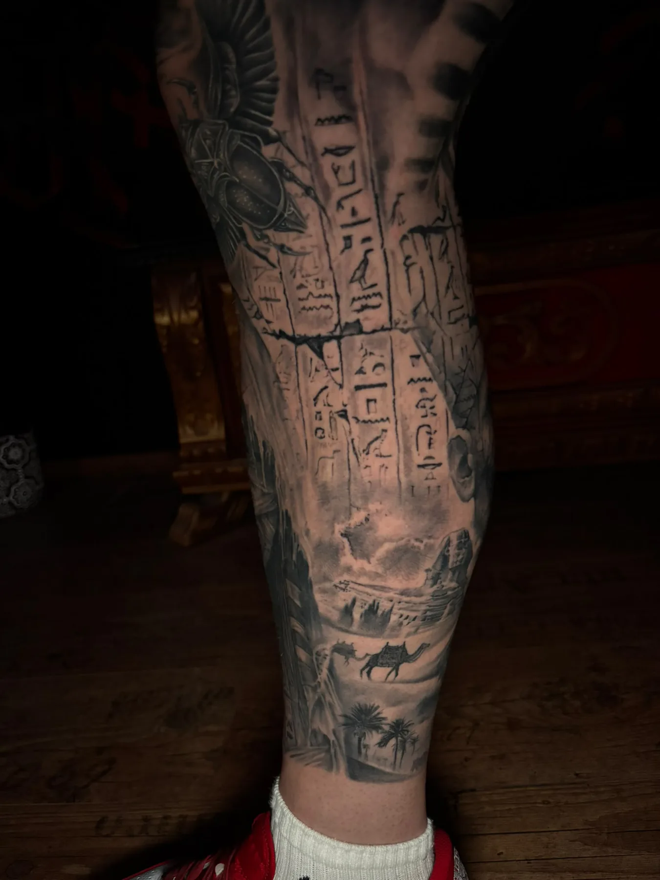 Black and grey calf tattoo with hieroglyphs, a scarab, pyramids, the Sphinx and a camel - Egyptian leg sleeve, Vienna