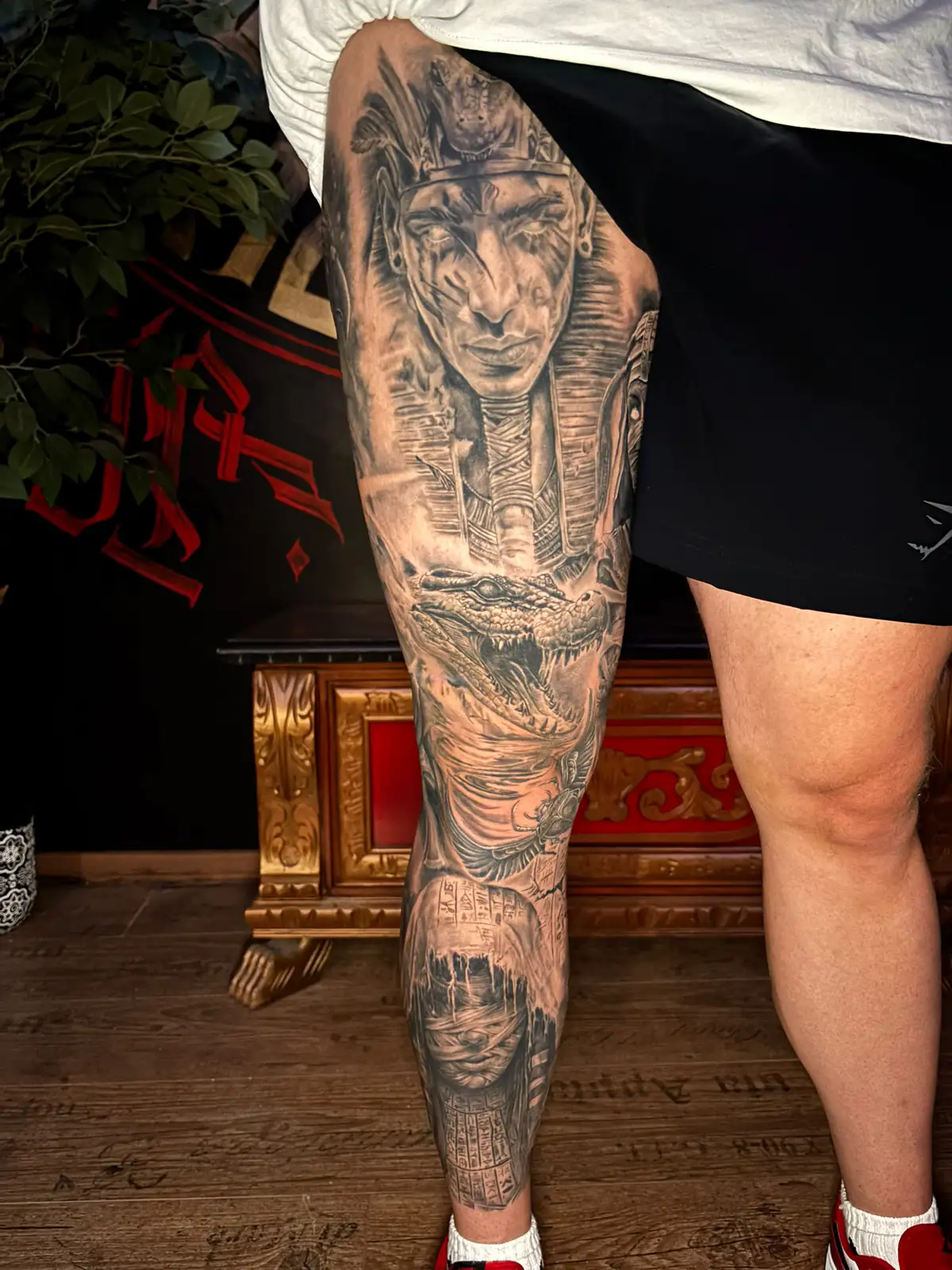 Full Egyptian leg sleeve in black and grey realism: a pharaoh, a crocodile and a veiled face, Ink21 Vienna