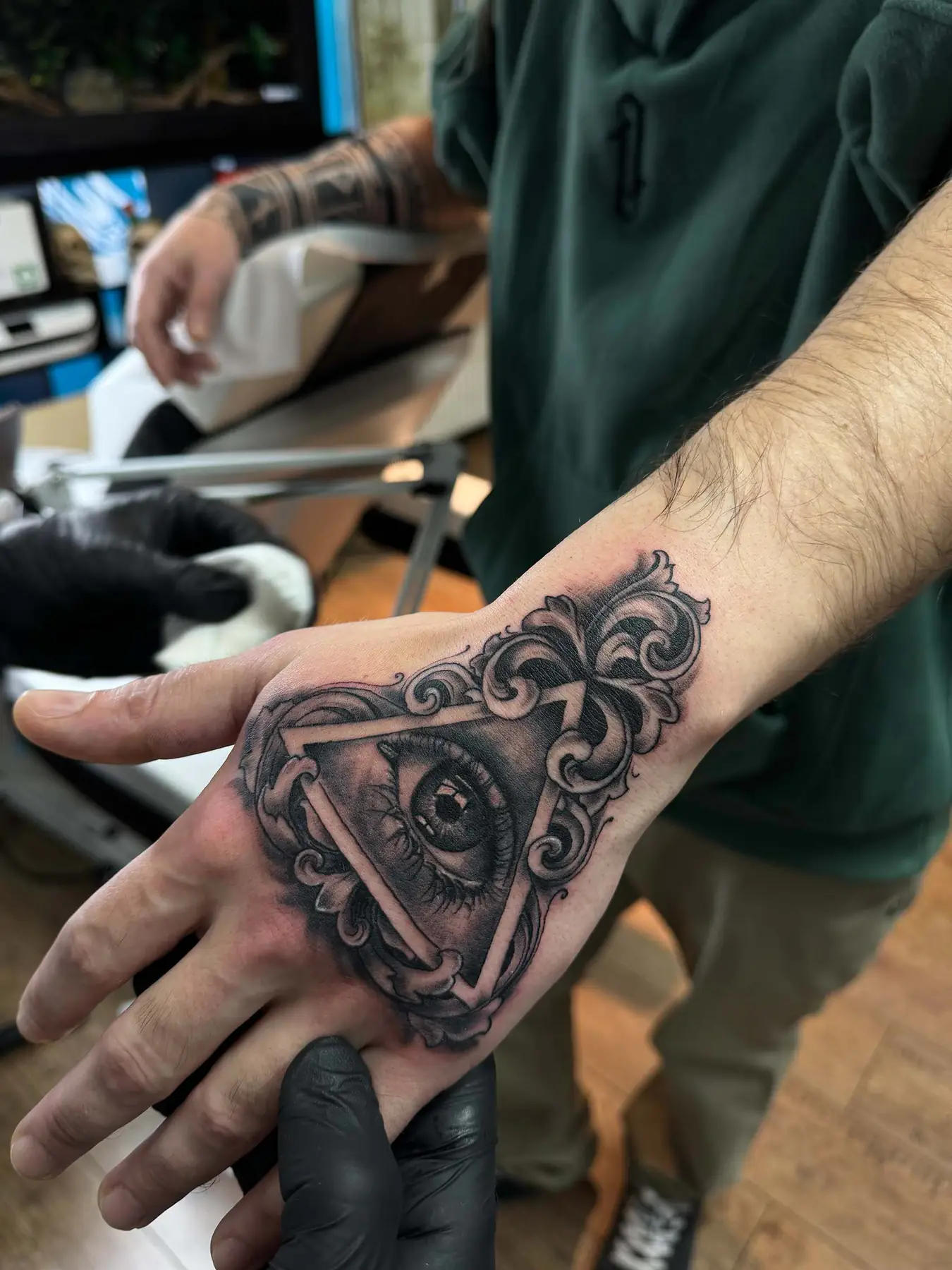 Eye in an ornate triangle on the hand. Tattoo at Ink21 in Vienna.