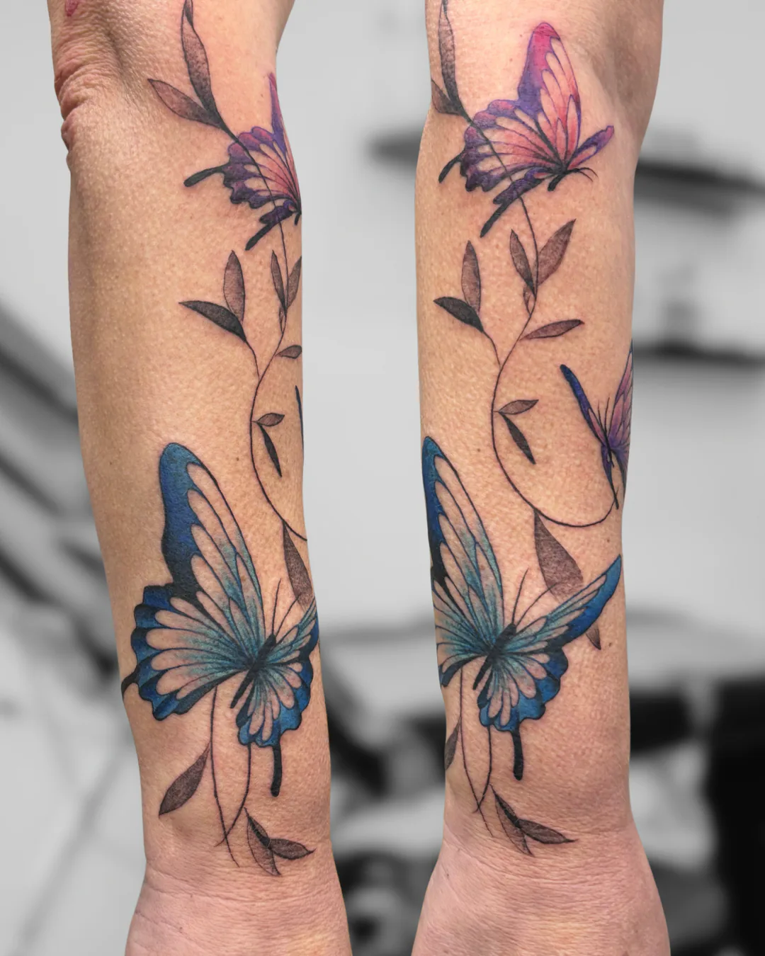 Blue butterflies and flowers. Tattoo at Ink21 in Vienna.