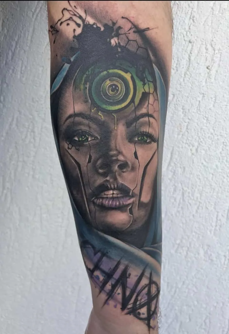 Double portrait with a green circular ornament. Tattoo at Ink21 in Vienna.