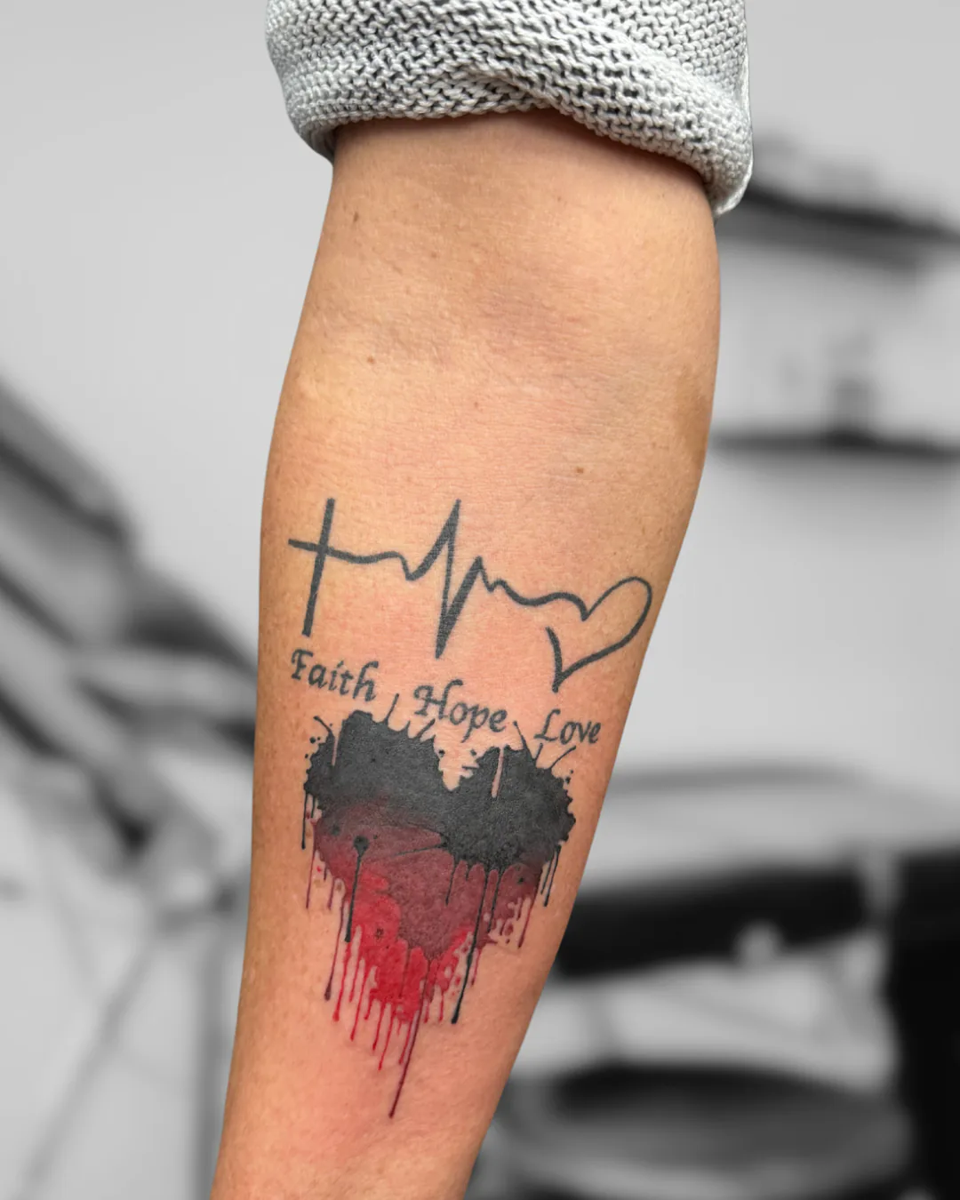 Faith Hope Love with a red heart. Tattoo at Ink21 in Vienna.