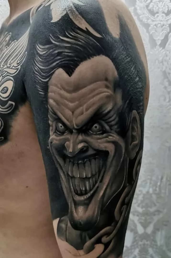 Grinning Joker on the upper arm. Tattoo at Ink21 in Vienna.