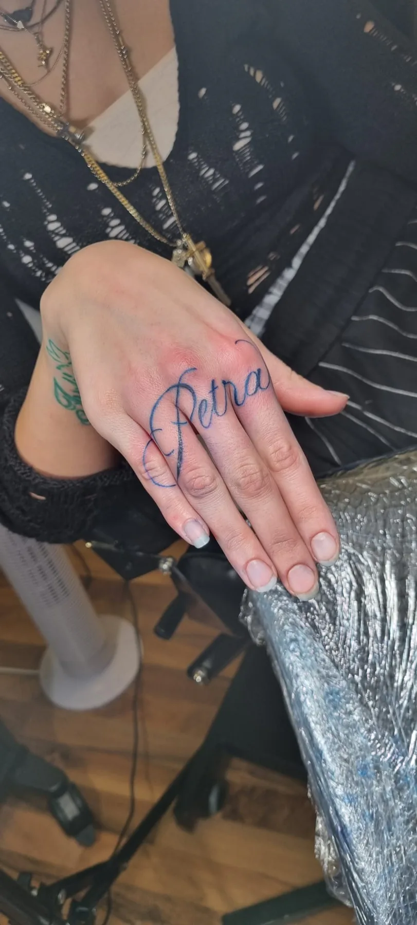 Large script lettering on the hand. Tattoo at Ink21 in Vienna.