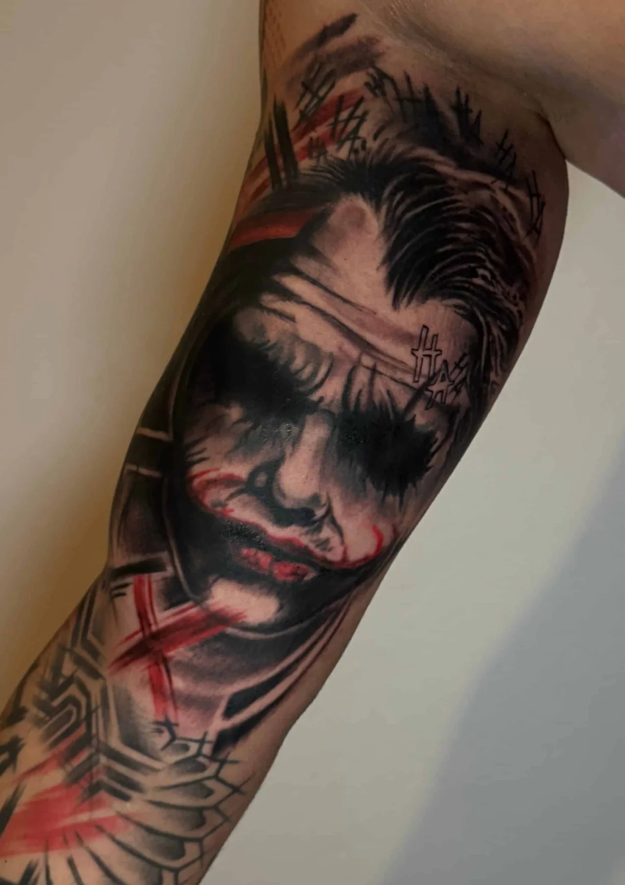 Joker portrait with red marks. Tattoo at Ink21 in Vienna.