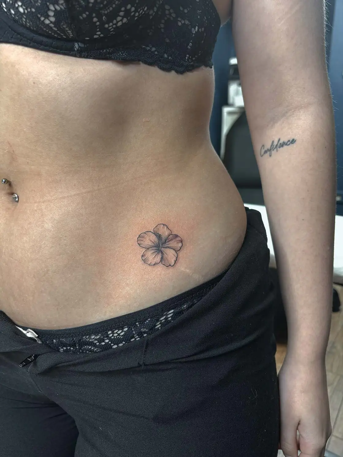 Small four-petalled flower on the hip. Tattoo at Ink21 in Vienna.