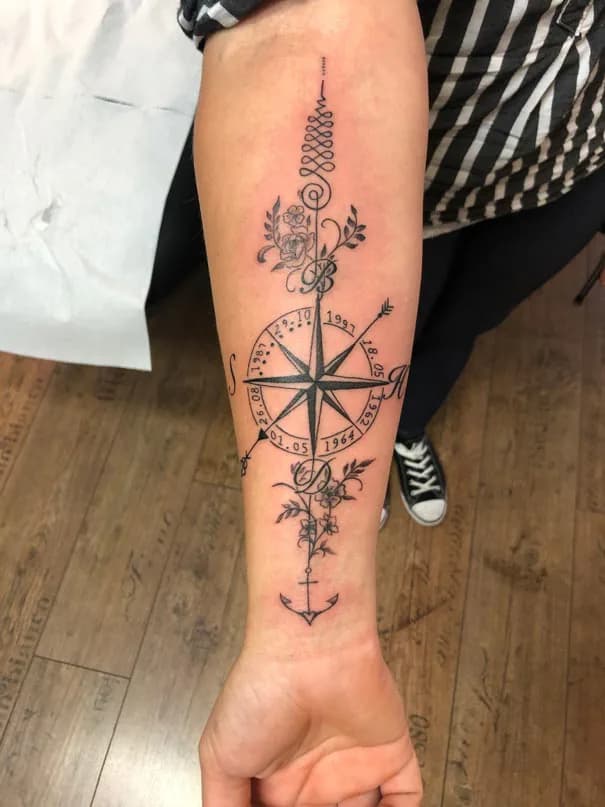 Compass with fine hanging ornaments. Tattoo at Ink21 in Vienna.
