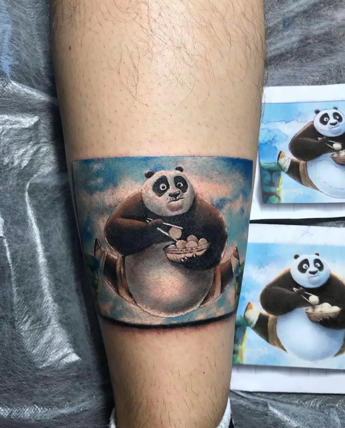Kung Fu Panda in a blue picture panel. Tattoo at Ink21 in Vienna.