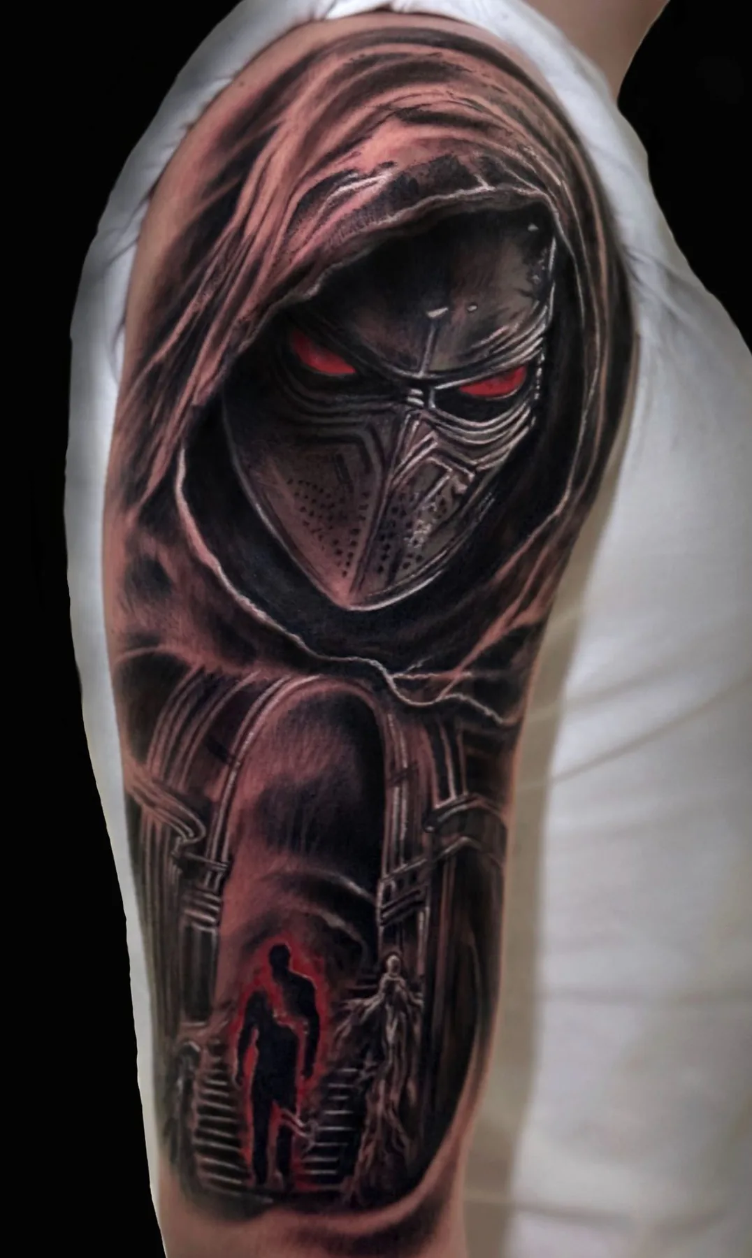 Masked hooded figure on the upper arm. Tattoo at Ink21 in Vienna.