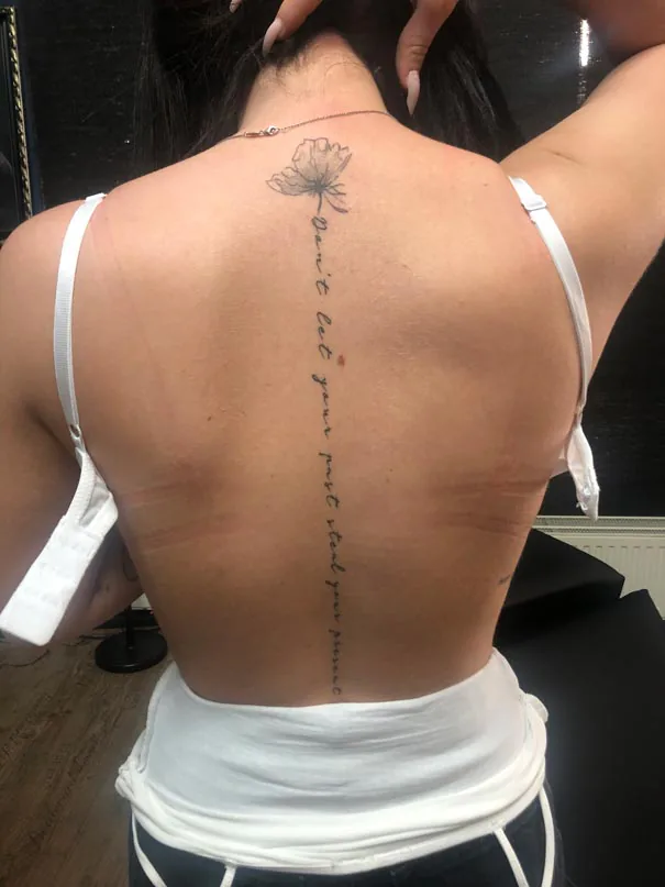 Rose and lettering along the spine. Tattoo at Ink21 in Vienna.