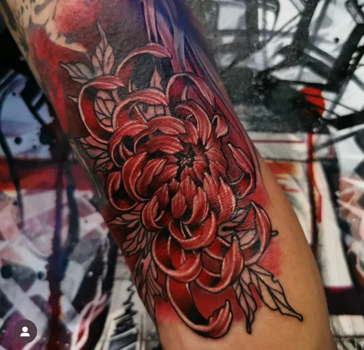 Red chrysanthemum with dark leaves. Tattoo at Ink21 in Vienna.