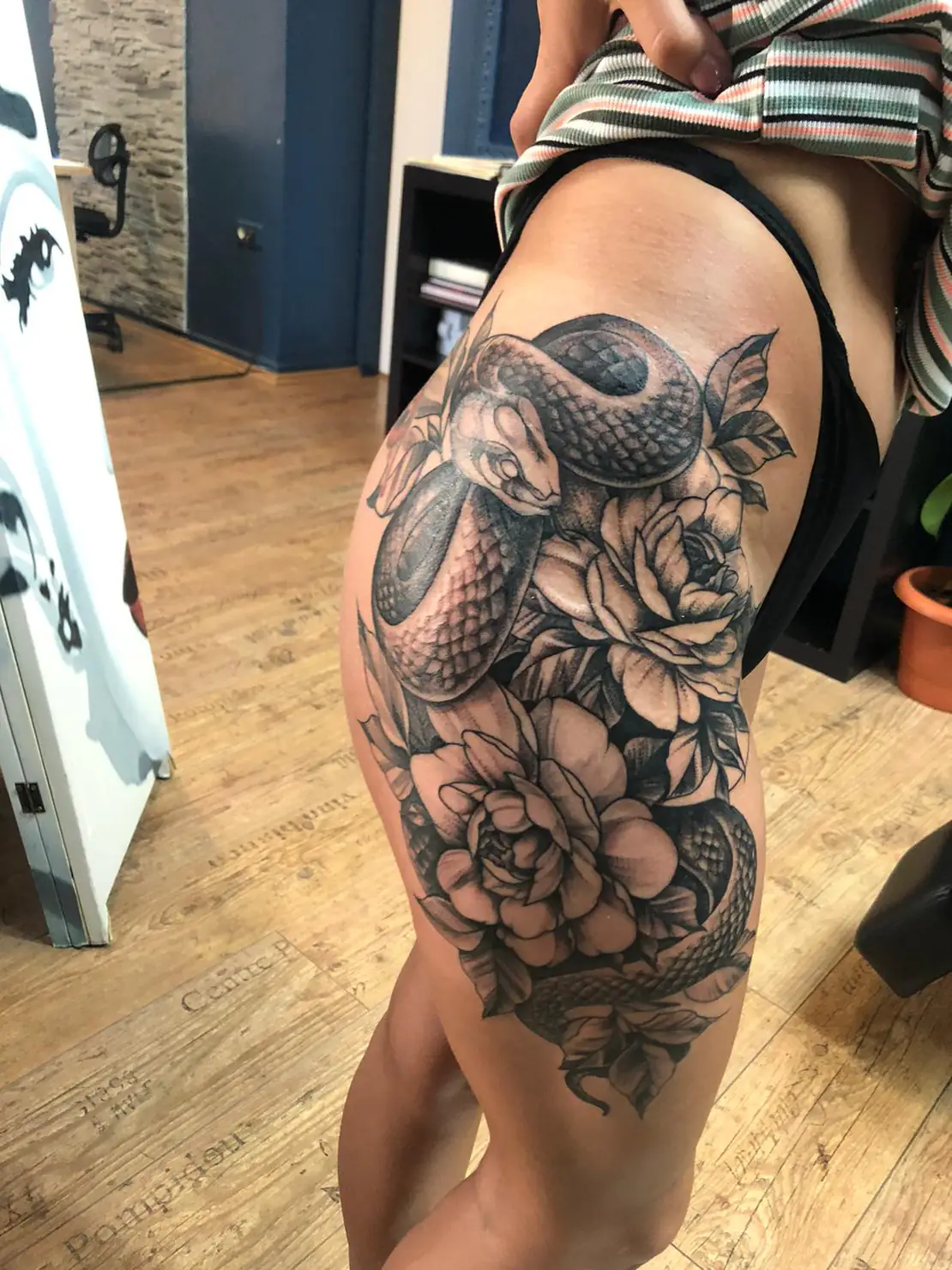 Snake with large thigh flowers. Tattoo at Ink21 in Vienna.