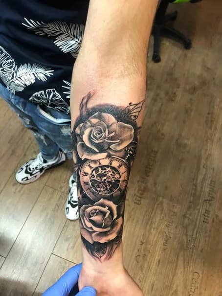 Pocket watch between forearm roses. Tattoo at Ink21 in Vienna.