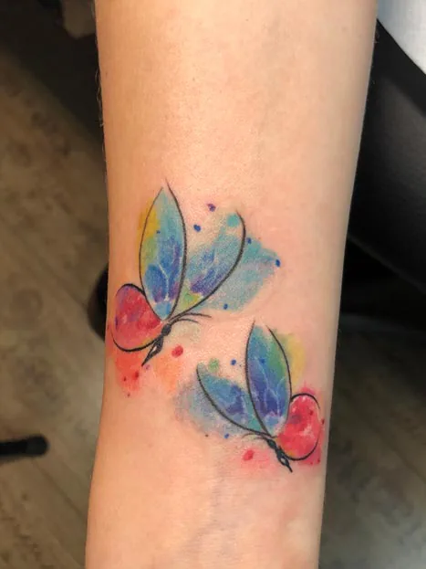 Two colourful butterflies at the ankle. Tattoo at Ink21 in Vienna.