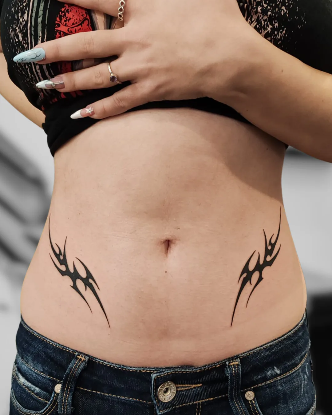 Two small tribal designs on the abdomen. Tattoo at Ink21 in Vienna.